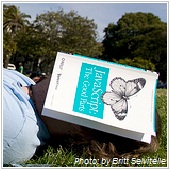 man's face covered by javascript book